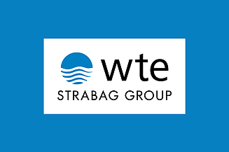 Logo der WTE - STRABAG GROUP auf blauem Hintergrund.