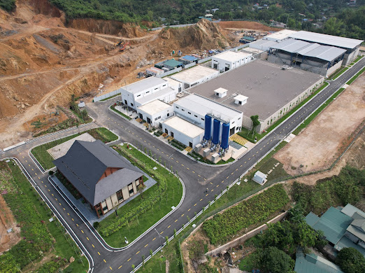 Aerial view of the Xuan-Mai Surface Water Treatment Plant in Hoa Binh, Vietnam, showing treatment buildings, access roads, and surrounding landscape.