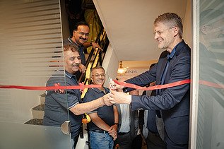 Siegfried Wanker joyfully cuts the red ribbon