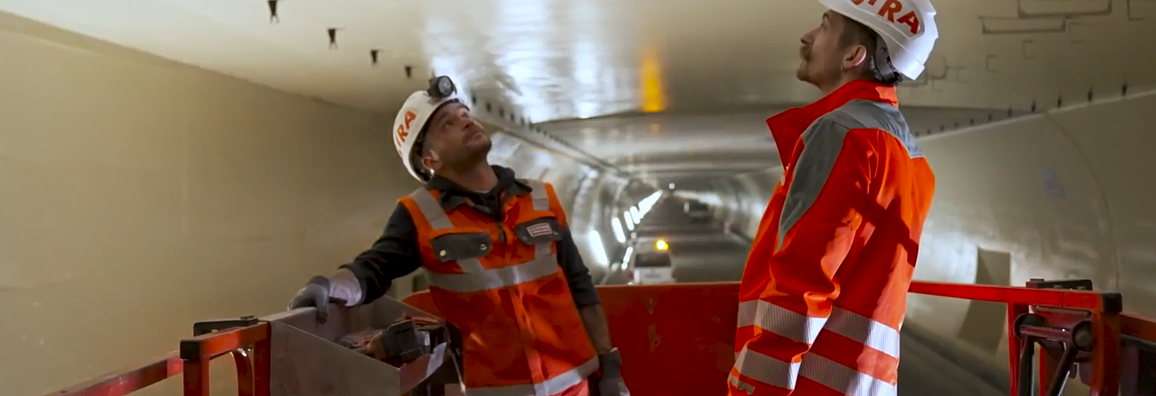 2 Bauarbeiter in Schutzkleidung blickt konzentriert nach oben schauen im Tunnelö