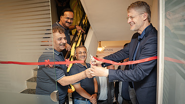 Siegfried Wanker joyfully cuts the red ribbon