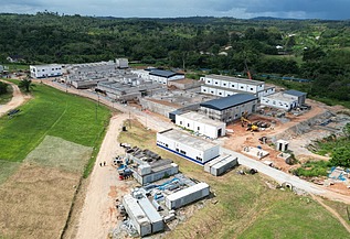 Luftaufnahme einer im Bau befindlichen großen Wasseraufbereitungsanlage, umgeben von grünen Hügeln und offenem Land.
