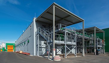 This image shows a state-of-the-art industrial processing facility featuring a robust steel framework with elevated platforms, stairways, and integrated piping systems.