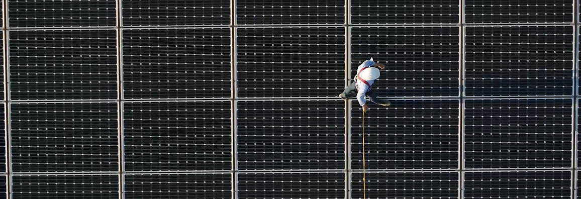 Mann läuft auf Solarpaneelen 