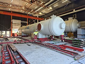 Präzise Positionierung von Wärmetauscherbehältern auf einem hydraulischen Schienensystem innerhalb der Montagehalle.