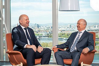 2 Manager hinter einem malerischen Blick auf Wien, Donau 