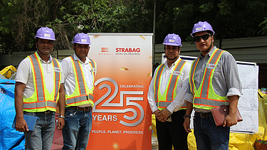 people in front of 25 years banner 